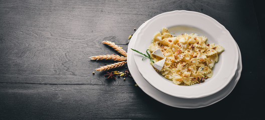 Pasta four cheeses. Italian food. On a wooden background. Top view. Free space for text.