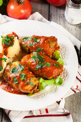 Stuffed cabbage with meat and rice served with boiled potatoes and tomato sauce