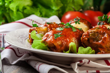 Stuffed cabbage with meat and rice served with boiled potatoes and tomato sauce