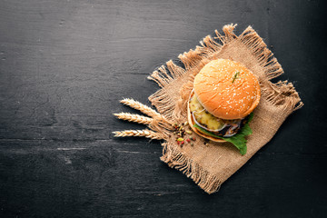 Obraz na płótnie Canvas Beef burger. On a wooden background. Top view. Free space for text.