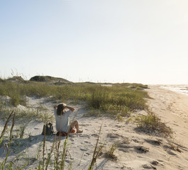 Seated Woman in the Beach Sand Dunes Greets the Rosy New Day