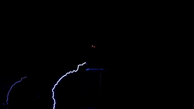 Performance on stage at the festival of science. A scientist in a special suit controls the electrical discharges in the dark