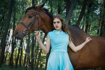 Girl and horse in summer in the forest in a dress