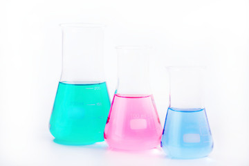 Chemical laboratory beakers with colorful liquids and reagents. 