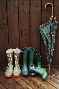 Rain boots with plaid umbrella on back porch