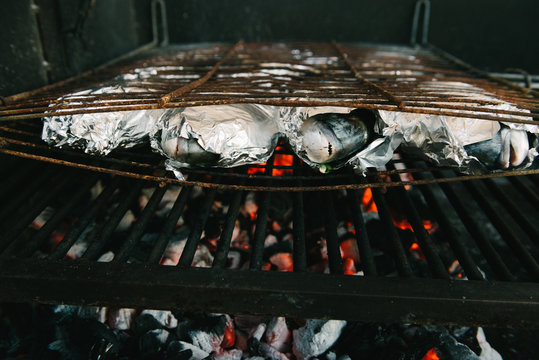 Fresh fish with lemon, garlic and herbs on barbeque grill - gilthead seabream