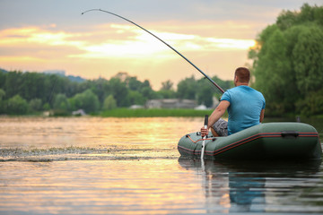 Man fishing from inflatable boat on river
