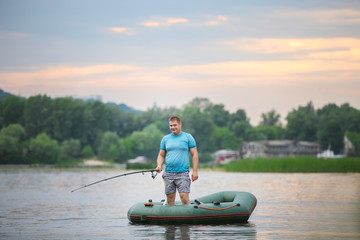 Man fishing from inflatable boat on river