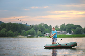 Man fishing from inflatable boat on river