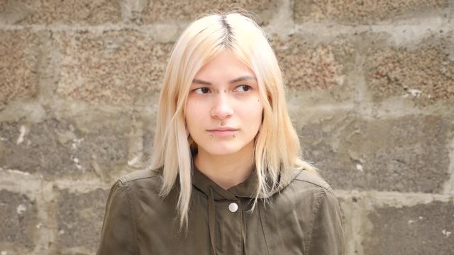 bodimodification, portrait of a girl with face piercings and tunnels in the ears. 4k, slow-motion shooting, copy space