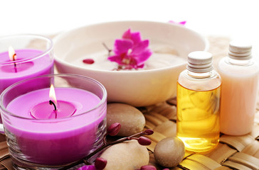 Obraz na płótnie Canvas essential oil, aromatherapy candles, pebbles and flowers