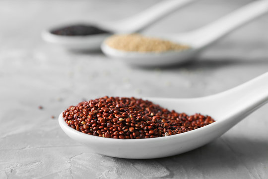 Spoon with quinoa seeds on table