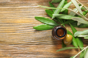 Glass bottle with olive oil on wooden table