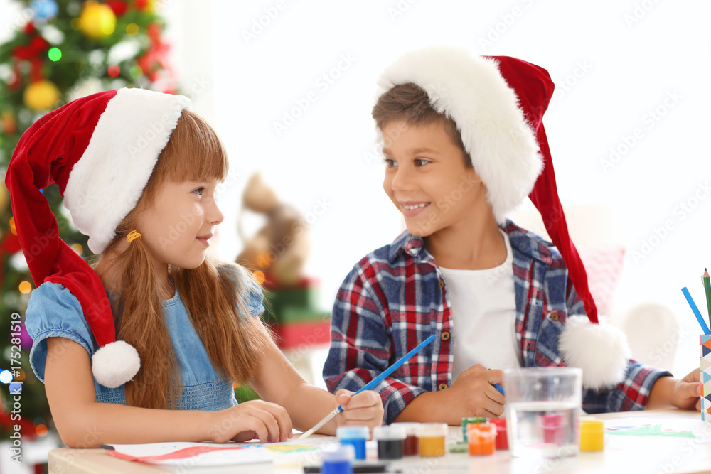 Wall mural cute children painting pictures for christmas at table