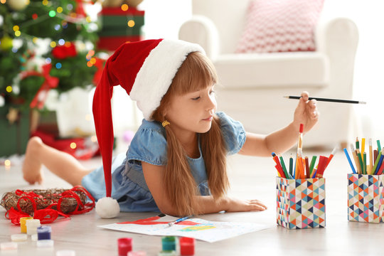 Cute girl drawing picture for Christmas on floor
