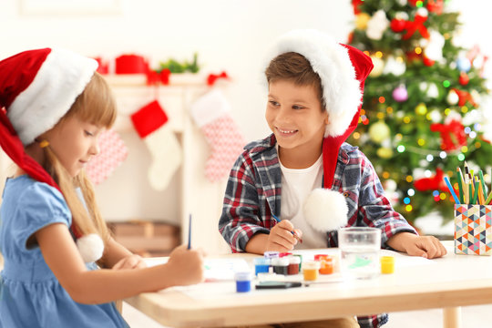 Cute children painting pictures for Christmas at table