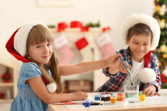 Cute children painting pictures for Christmas at table