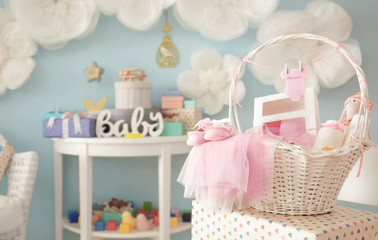Wicker basket with gifts for baby shower indoors - obrazy, fototapety, plakaty