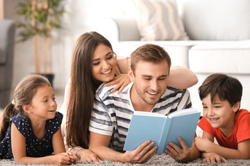 Happy family reading book at home