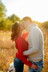young loving couple hugging at sunset in autumn at an outdoor park