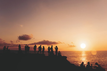 Anonymous, unrecognizable silhouetted group of people watching beautiful sunset