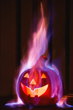 Evil halloween pumpkin burning in a dark room