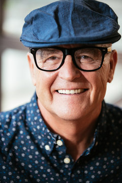Senior stylish man portrait wearing a beret and glasses