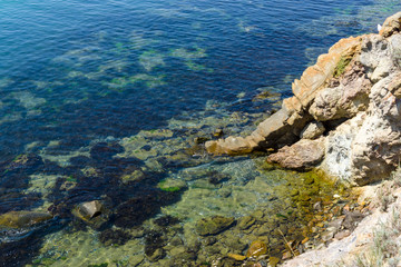 Blue sea, calm. Rocky shores and the bottom of the sea. View from above.