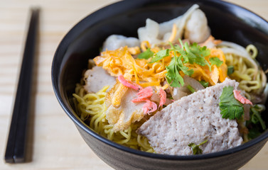 Chinese egg noodles and pork on wood table