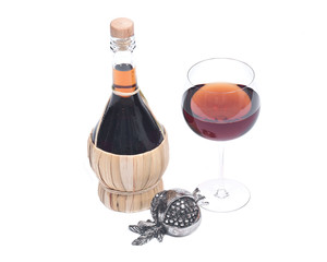 Red pomegranate wine in glass and straw wine bottle with shabbat metal decoration isolated on white background