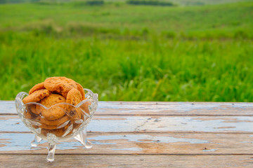 Chocolate cookies on a wooden table with nature background