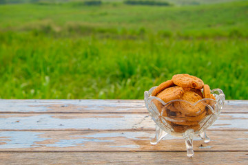 Chocolate cookies on a wooden table with nature background