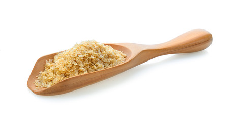 amaranth seeds on wooden scoop over white background