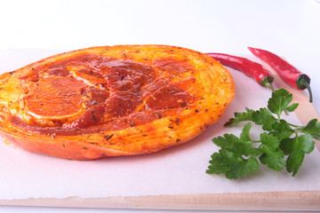 Raw Pork ham with spices, parsley leaves and chilli ready for BBQ grilling isolated on white background.