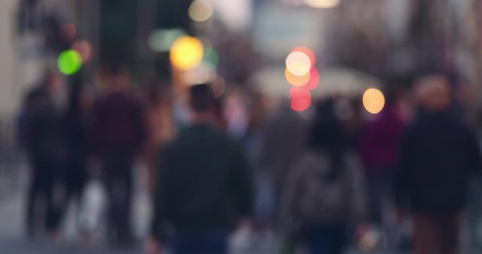 People Walking in Big City, Street Lights Background. SLOW MOTION 4K. Abstract crowd and traffic. Out of focus footage from busy city with unrecognizable people crossing the street at dusk.