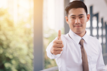 Business asian man shows thumb up.