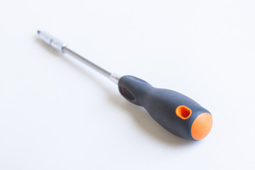 Screwdriver on a light background. Grey plastic handle with orange accents.