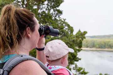 Mom hiking with baby using binoculars