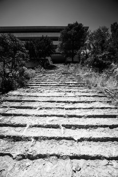 Stone steps leading to an old abandoned hotel.