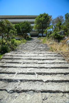 Stone steps leading to an old abandoned hotel.
