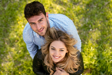 Fototapeta premium Top view. cheerful couple, standing barefoot in the grass looking at camera.