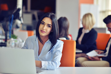 Businesswoman sits at a desk in front of a computer