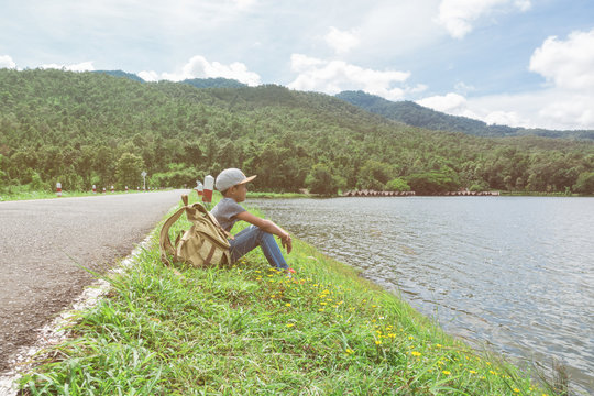 young asian boy traveling alone at nature park, vintage tone