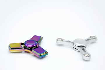 Two metal fidget spinners on white background with copy space.