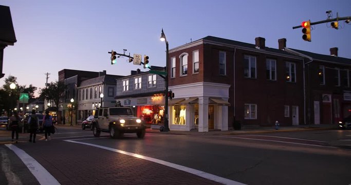 A dusk establishing shot of businesses on a typical Main Street in America. Pittsburgh suburb.	Building names and addresses obscured.  	