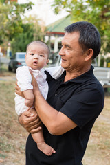 Grandmother holding adorable baby granddaughter in his arms