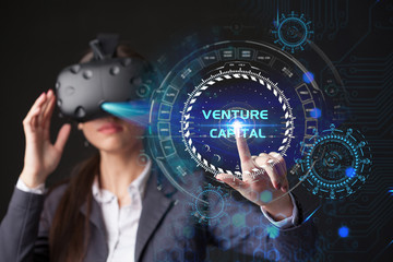 Young businesswoman working in virtual glasses, select the icon venture capital on the virtual display.