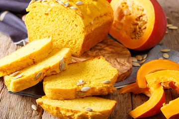 Fresh baked pumpkin bread on wooden board with seeds. horizontal