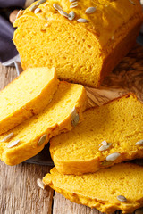 Homemade yellow pumpkin bread with seeds macro on the table. vertical