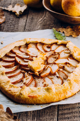 Homemade galette with pears and nuts on wooden rustic background. Sweet open fruit pie. Autumn bakery. Top view, copy space
